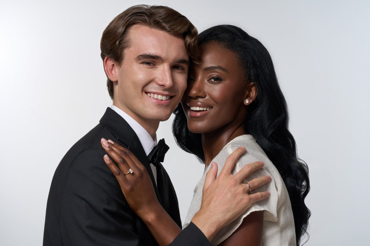 Two people embracing against a white background